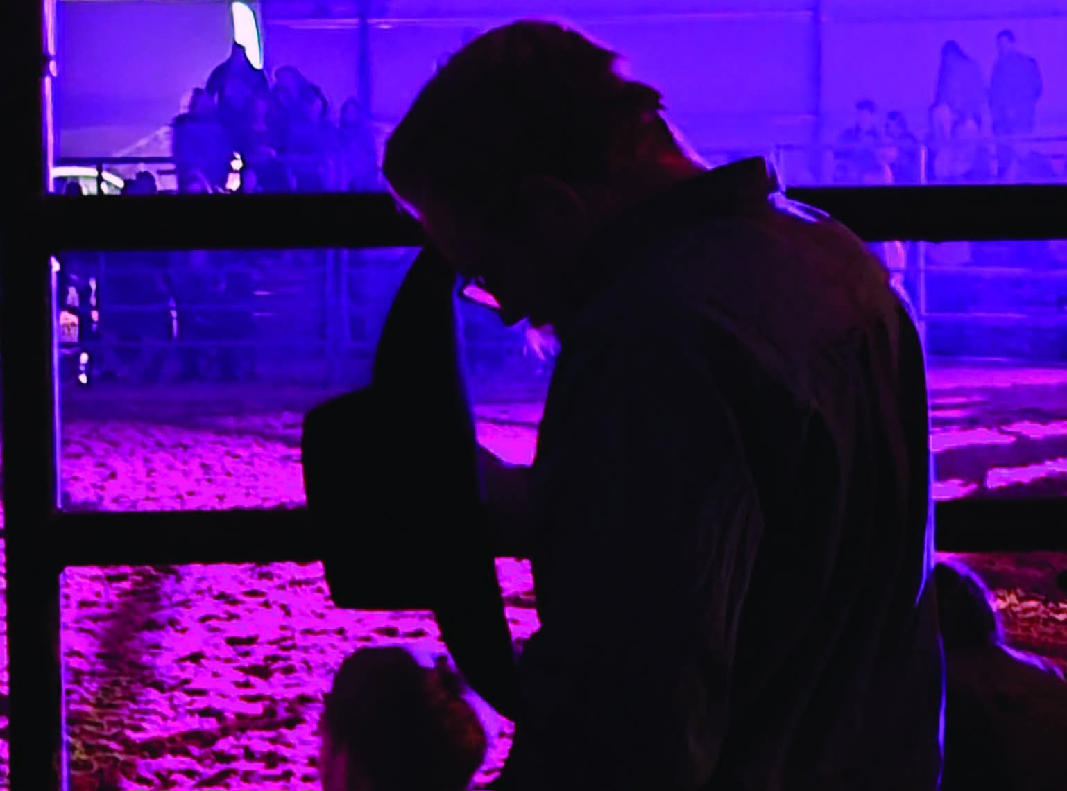 A Christian rodeo cowboy pauses to pray under the lights