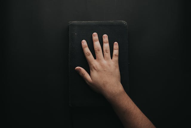 A hand on a Bible demonstrates swearing an oath